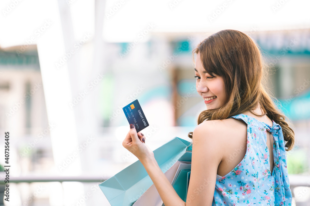 Young adult asian woman holding credit card and shopping bags. Young adult asian woman holding credit card and shopping bags.