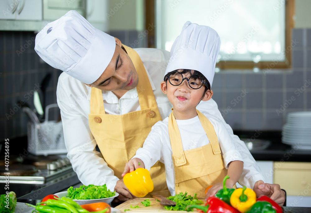 Happy family Asian man young father with son boy cooking healthy salad for the first time. first lesson and healthy lifestyle concept. Happy family Asian man young father with son boy cooking healthy salad for the first time. first lesson and healthy lifestyle concept.