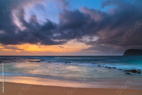 Fototapeta Naklejka Na Ścianę i Meble -  Sunrise at the seaside with rain clouds rolling in