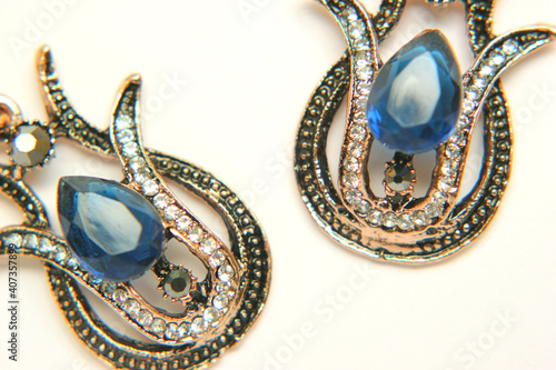Oriental Turkish women's jewelry with blue gem in the form of a tulip on a white background