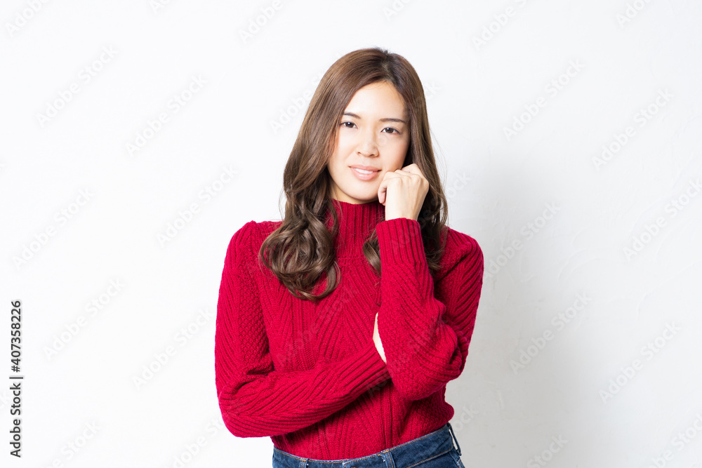 白い壁の前に立って、ポーズをとる若い女性 白い壁の前に立って、ポーズをとる若い女性