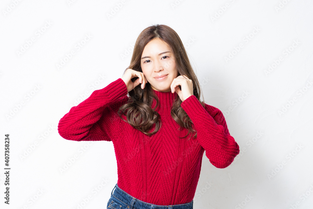 白い壁の前に立って、ポーズをとる若い女性 白い壁の前に立って、ポーズをとる若い女性