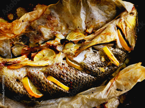 Roasted fish Barbel in a pan with onions and spices.