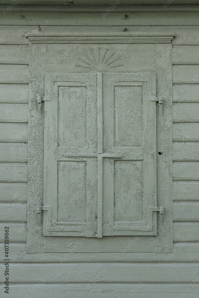 closed shutters painted in the same green color as the wall closed shutters painted in the same green color as the wall