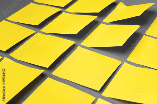 Yellow adhesive notes on gray background close up