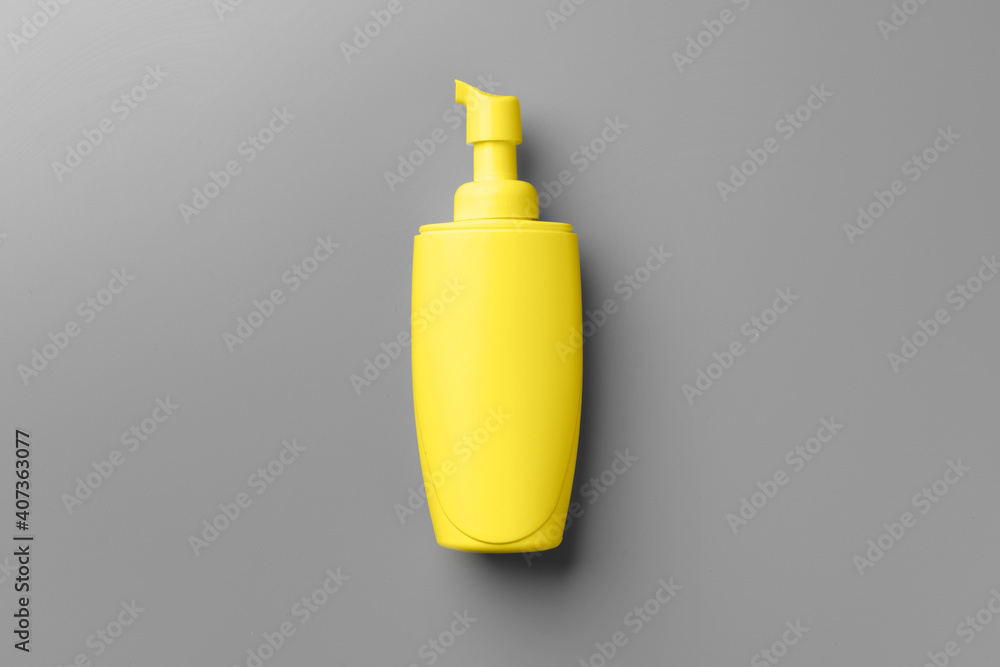 Yellow cosmetic container on gray background top view Yellow cosmetic container on gray background top view