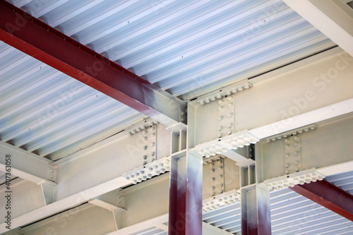  steel structure of building with steel beams, variety of joints and fasteners is partially covered with fire retardant materials and fire protection paint.