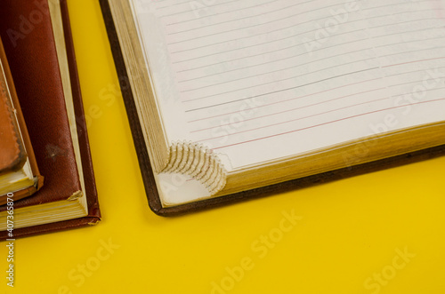 Close-up of old diaries on yellow background.