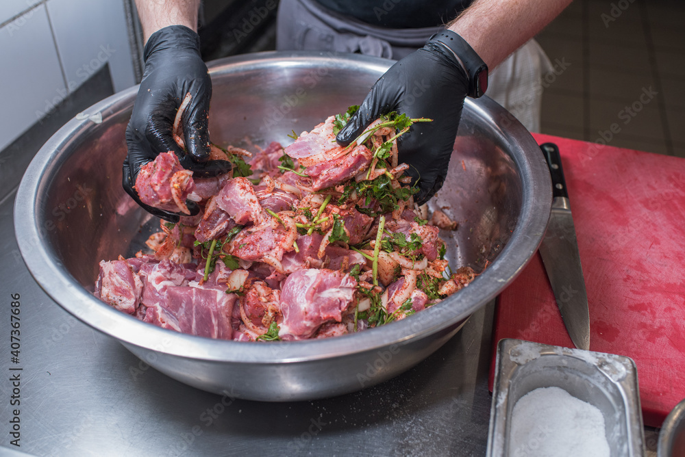 The chef marinates pork meat. Delicious food in the restaurant The chef marinates pork meat. Delicious food in the restaurant