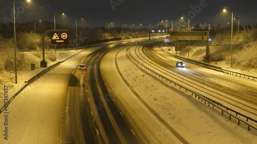 Snowing in Manchester at night. High angle view of recently upgraded to smart Motorway M60 at junction 8. Snow is rarely seen in North West.