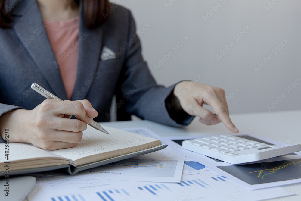Head of accounting is recording the company's financial growth statistics using graphs as a reference for reviewing and analyzing the results, Taking notes and analyzing data graphs in office. Head of accounting is recording the company's financial growth statistics using graphs as a reference for reviewing and analyzing the results, Taking notes and analyzing data graphs in office.