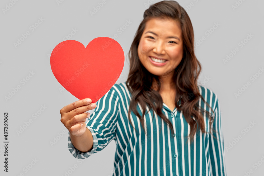 love, charity and valentines day concept - happy asian young woman with red heart over grey background love, charity and valentines day concept - happy asian young woman with red heart over grey background