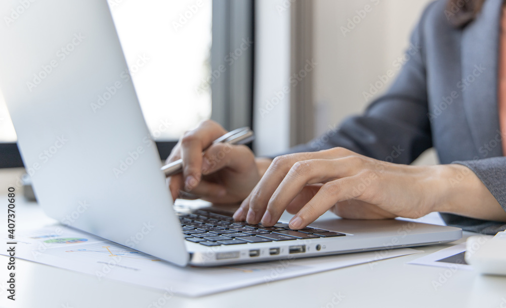 Close-up of a woman's hand pressing on the laptop keyboard,World of technology and internet communication, Financial professionals use laptop to calculate and check real estate earnings. Close-up of a woman's hand pressing on the laptop keyboard,World of technology and internet communication, Financial professionals use laptop to calculate and check real estate earnings.