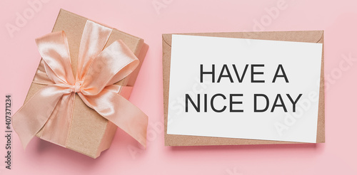 Gifts with note letter on isolated pink background, love and valentine concept with text HAVE A NICE DAY