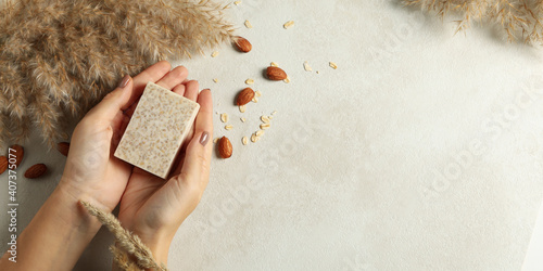 Female hands hold handmade soap on decorated background photo