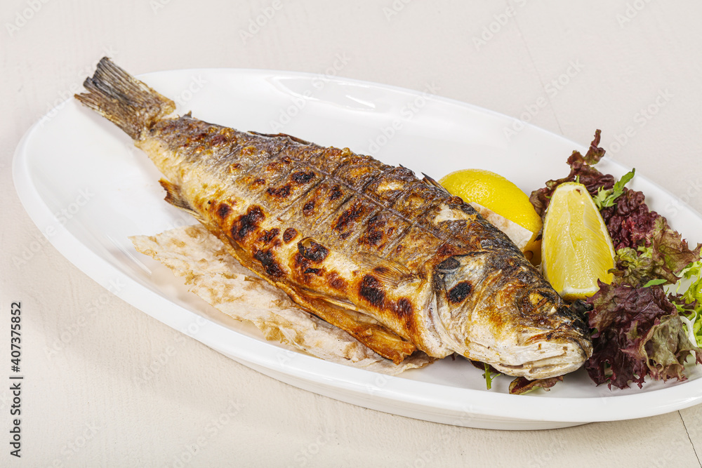 Grilled seabass fish served lemon Grilled seabass fish served lemon
