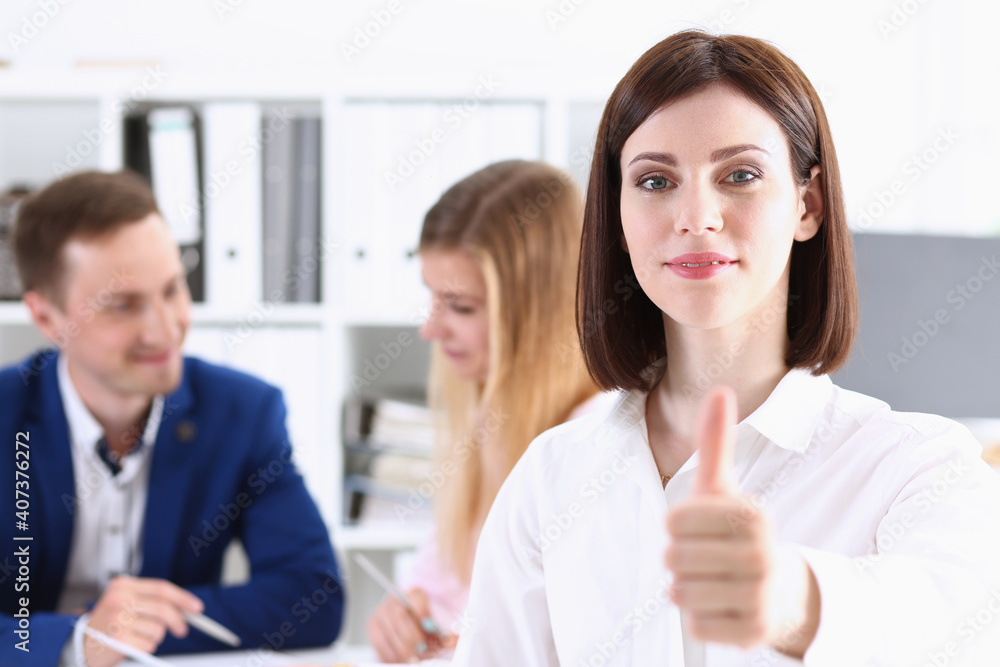 Female arm show OK or approval with thumb up in creative people office closeup. High level quality product, serious offer conference, mediation solution, advisor participation concept Female arm show OK or approval with thumb up in creative people office closeup. High level quality product, serious offer conference, mediation solution, advisor participation concept