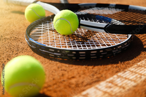 Tennis balls and rackets on clay court, closeup © New Africa