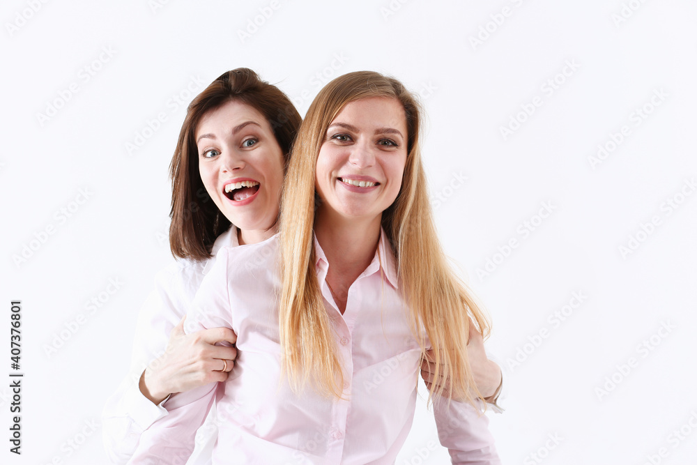 Two smiling happy joyful female friends portrait looking in camera over white background. Homosexual marriage, lesbian couple, love relations, modern positive relationship concept Two smiling happy joyful female friends portrait looking in camera over white background. Homosexual marriage, lesbian couple, love relations, modern positive relationship concept