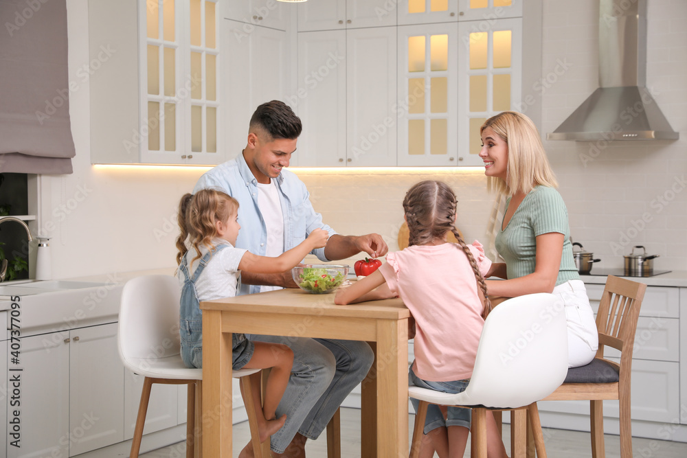 Happy family cooking together at table in modern kitchen Happy family cooking together at table in modern kitchen