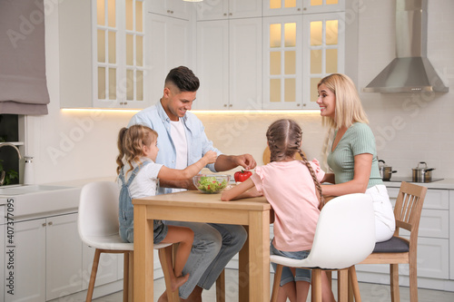 Happy family cooking together at table in modern kitchen