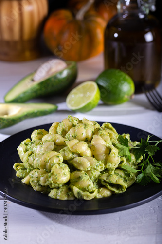 Pasta with pesto sauce on wooden background.