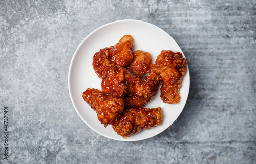 Top view Korean spicy fried chicken on gray concrete table.