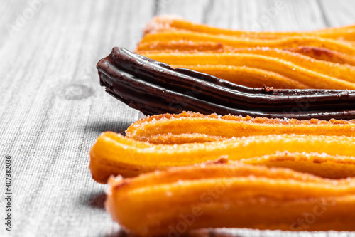 Churros in a row, all are sugar except one that is chocolate on an elegant gray background. Photo of psychology