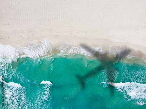 Drone photo of empty Playa Ballenas with small airplane shadow, Cancun, Mexico