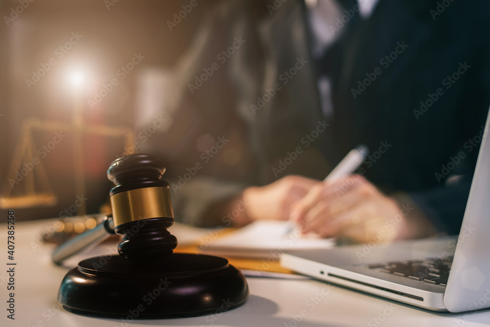 Justice and law concept.Male judge in a courtroom the gavel, working with digital tablet computer on wood table. Justice and law concept.Male judge in a courtroom the gavel, working with digital tablet computer on wood table.