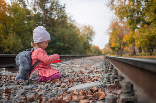 gender differences in children. cute little girl plays on the railway tracks