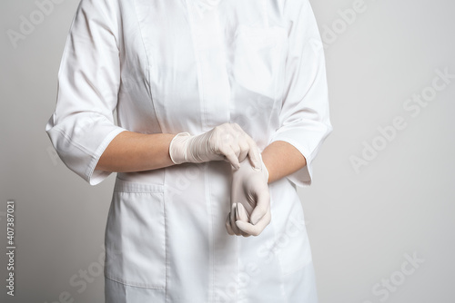 Cropped view of doctor putting a white latex gloves for protective virus. Medicine and healthcare concept