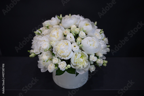 White peonies collected in a composition. Fresh, natural flowers, on a dark background
