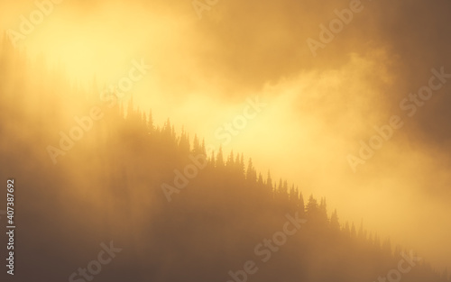 Dramatic orange sunset in mountains in the foggy Pacific Northwest in winter 
