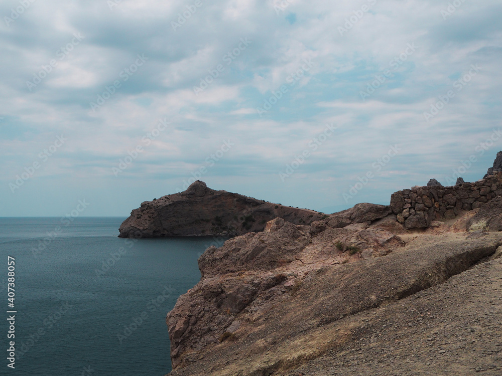 Mountain range protruding into the sea. Calm sea surface. Beautiful landscape.