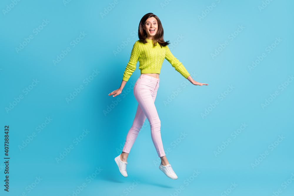 Full length photo portrait of excited girl walking jumping up isolated on pastel blue colored background