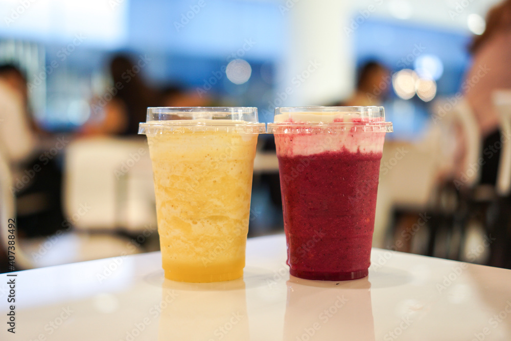 Two cup of fruit smoothie, pineapple and dragon fruit on a white table at cafe. Two cup of fruit smoothie, pineapple and dragon fruit on a white table at cafe.