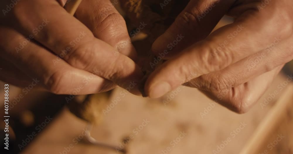 Artist sculpting or shaping figure hand detail with clay tool macro Artist sculpting or shaping figure hand detail with clay tool macro