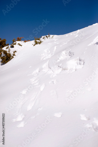 Footprint on snow mountain hill against blue sky