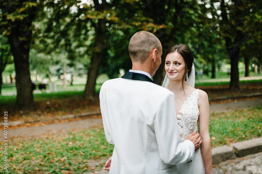 The bride and groom looking and standing in the park. The bride and groom looking and standing in the park.