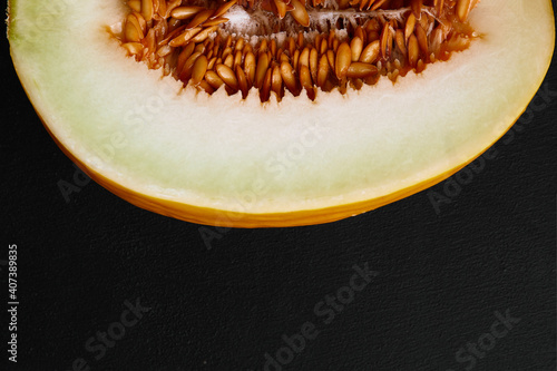 Studio shot of notched ripe melon galia isolated on black background