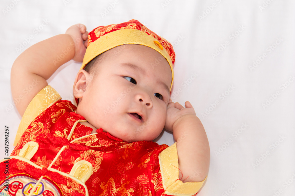 Adorable Asian Chinese healthy baby lie down on bed looking for mom feeding, happy cute boy infant playing alone feeling happy, Chinese New Year wealthy prosperous Traditional Festival concept Adorable Asian Chinese healthy baby lie down on bed looking for mom feeding, happy cute boy infant playing alone feeling happy, Chinese New Year wealthy prosperous Traditional Festival concept