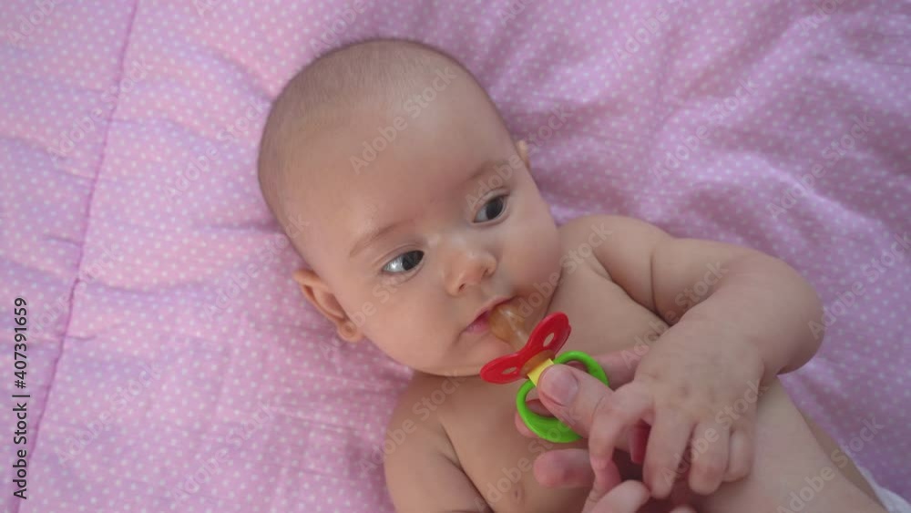 Mom gives a pacifier to her newborn daughter Mom gives a pacifier to her newborn daughter