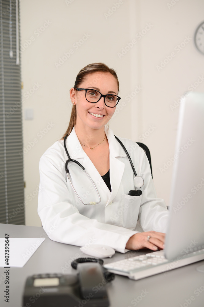 portrait of a beautiful woman female doctor in medical practice office working on computer portrait of a beautiful woman female doctor in medical practice office working on computer