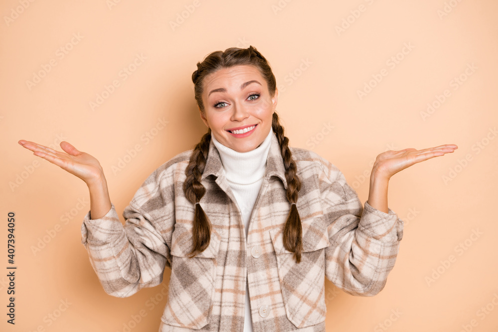 Portrait of optimistic funny girl shrug shoulders wear white shirt isolated on beige color background Portrait of optimistic funny girl shrug shoulders wear white shirt isolated on beige color background