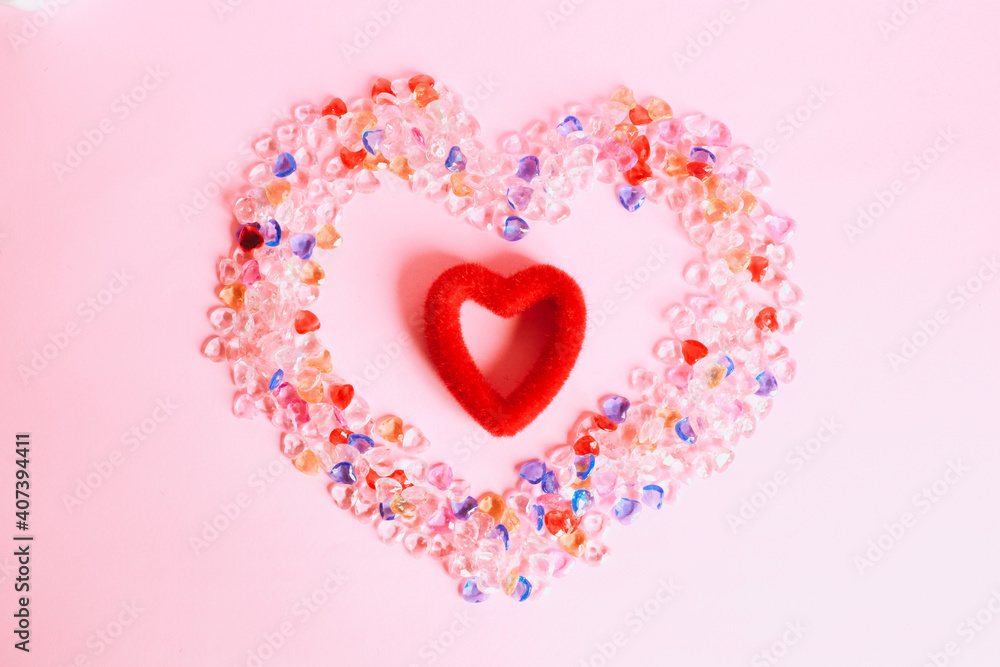 Colorful heart shape marbles with red heart shape in the middle isolated on pink background