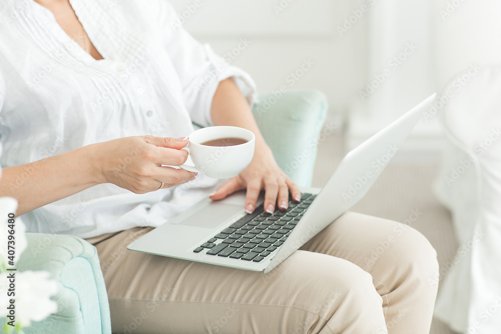 Midadult woman typing on laptop indoors. Female browsing Midadult woman typing on laptop indoors. Female browsing