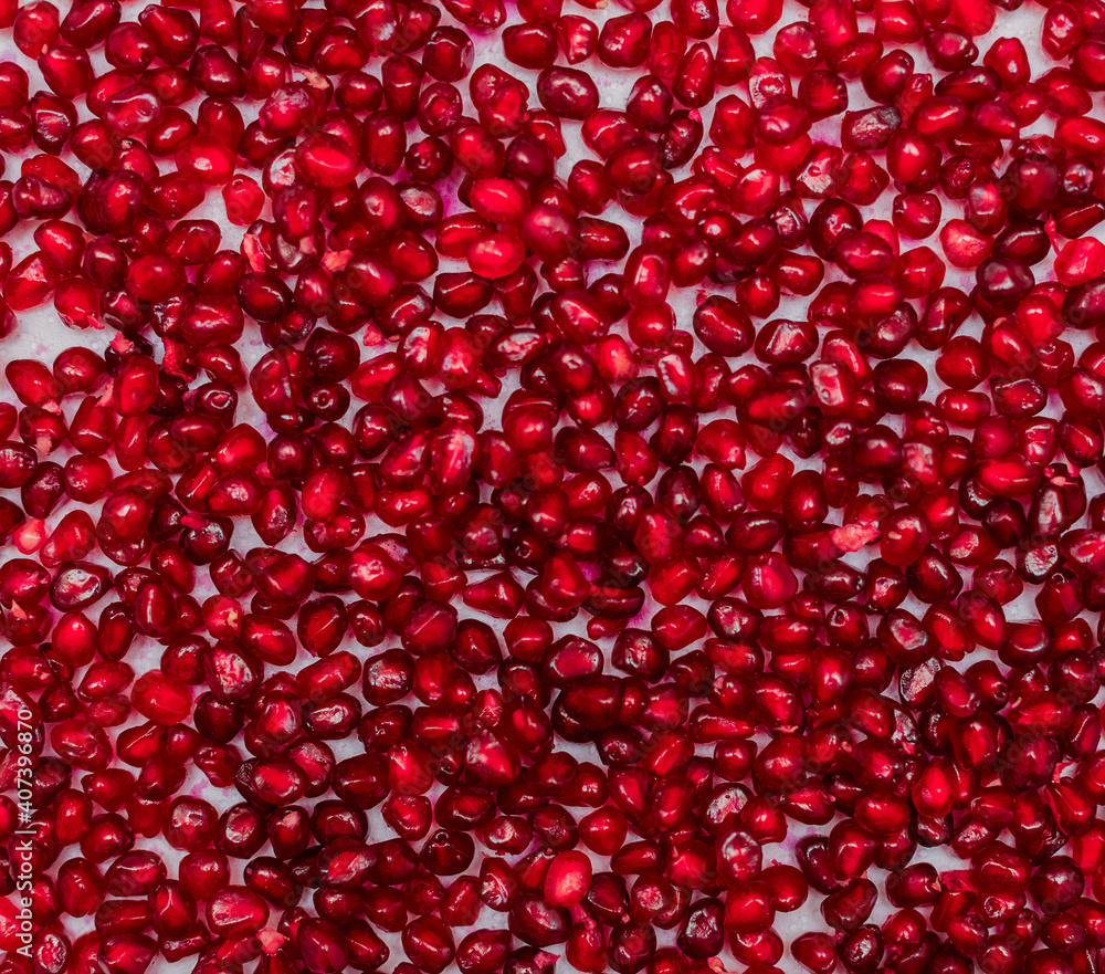 Red pomegranate seeds on a white background. Close-up. Fruit, food. Photophone, wallpaper, texture, texture. Copy space. Red pomegranate seeds on a white background. Close-up. Fruit, food. Photophone, wallpaper, texture, texture. Copy space.
