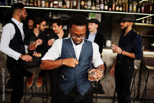 Fotografija Stylish african american man against group of handsome retro well-dressed guys gangsters spend time at club, drinking on bar counter