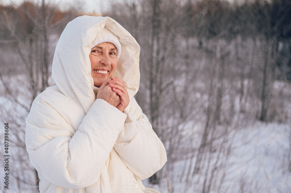 Happy elderly senior mature woman in white warm outwear playing with snow in sunny winter outdoors. Retired healthy people holiday vacation winter activities, active lifestyle concept. Happy elderly senior mature woman in white warm outwear playing with snow in sunny winter outdoors. Retired healthy people holiday vacation winter activities, active lifestyle concept.